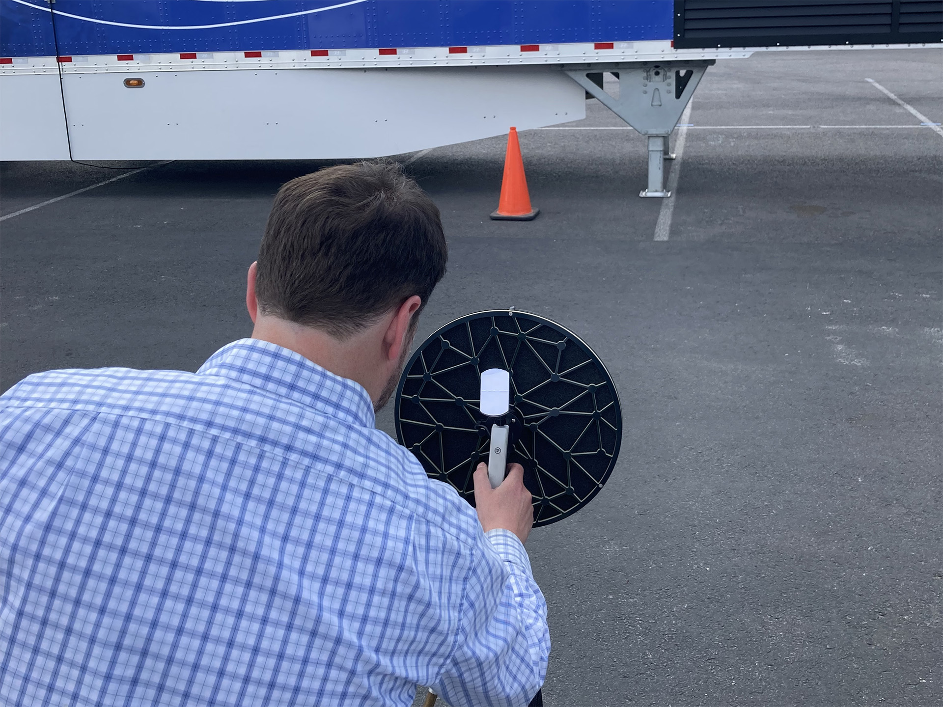 An acoustic engineer using a B&K acoustic camera array to identify the sources of noise coming from an outdoor mobile power generation unit.