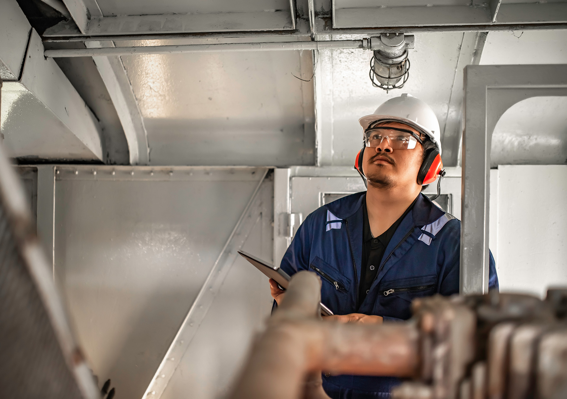 Engine engineer inspecting large machines in factory, railway engine maintenance technician, engine repair mechanical manager
