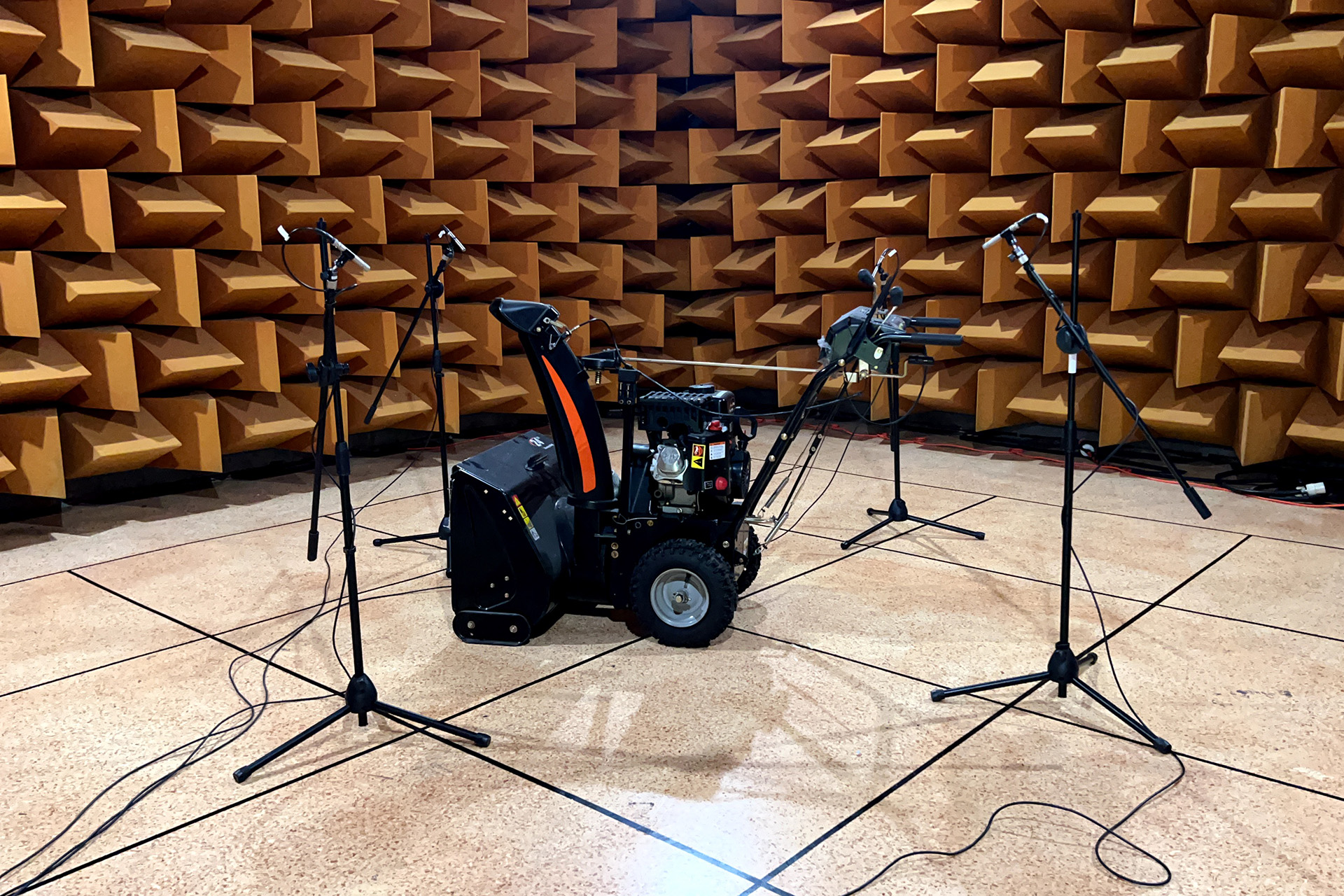 Small engine equipment surrounded by microphones for acoustic testing in the Soundcoat hemi-anechoic chamber in Deer Park, NY