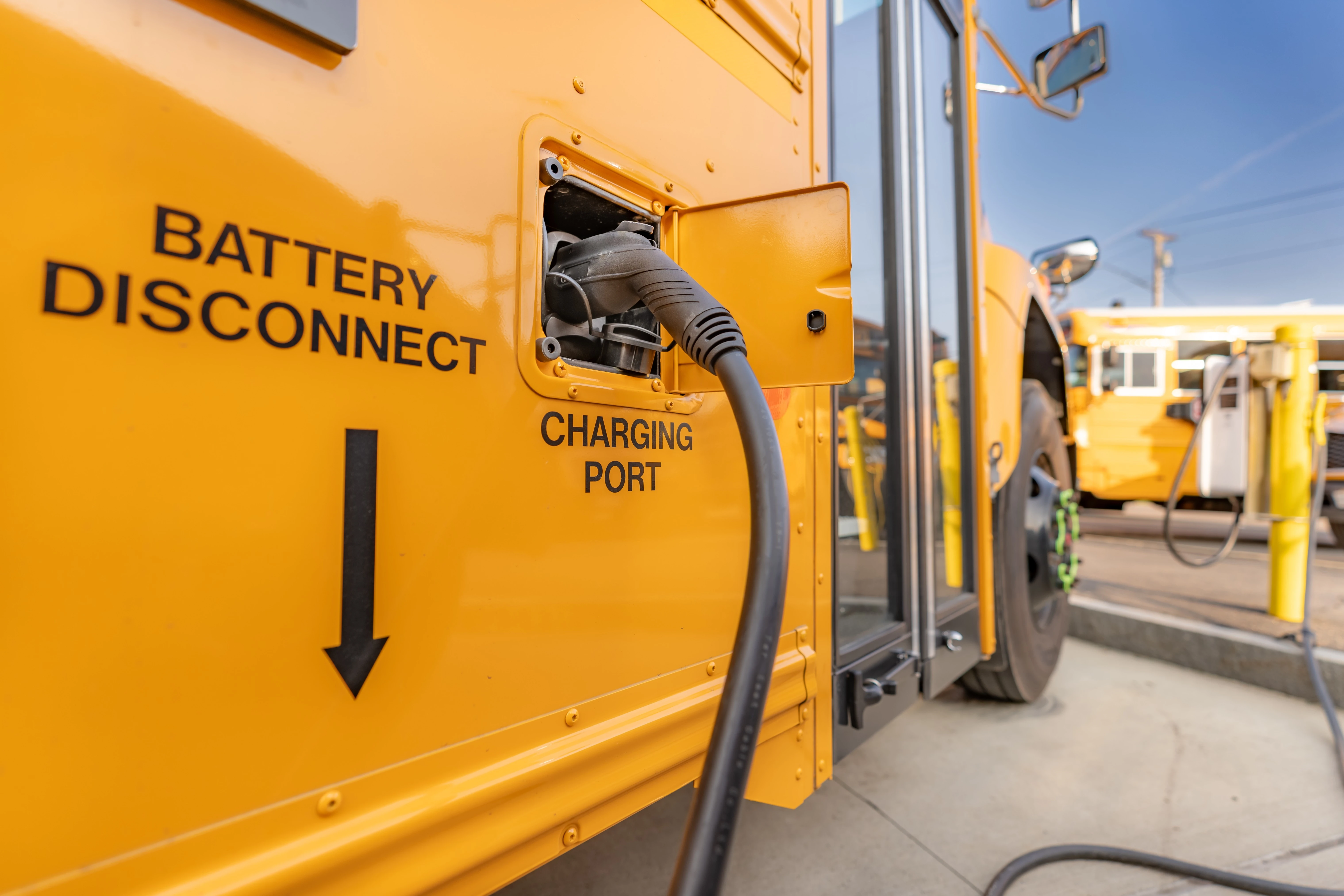 Electric school bus plugged into charging station.